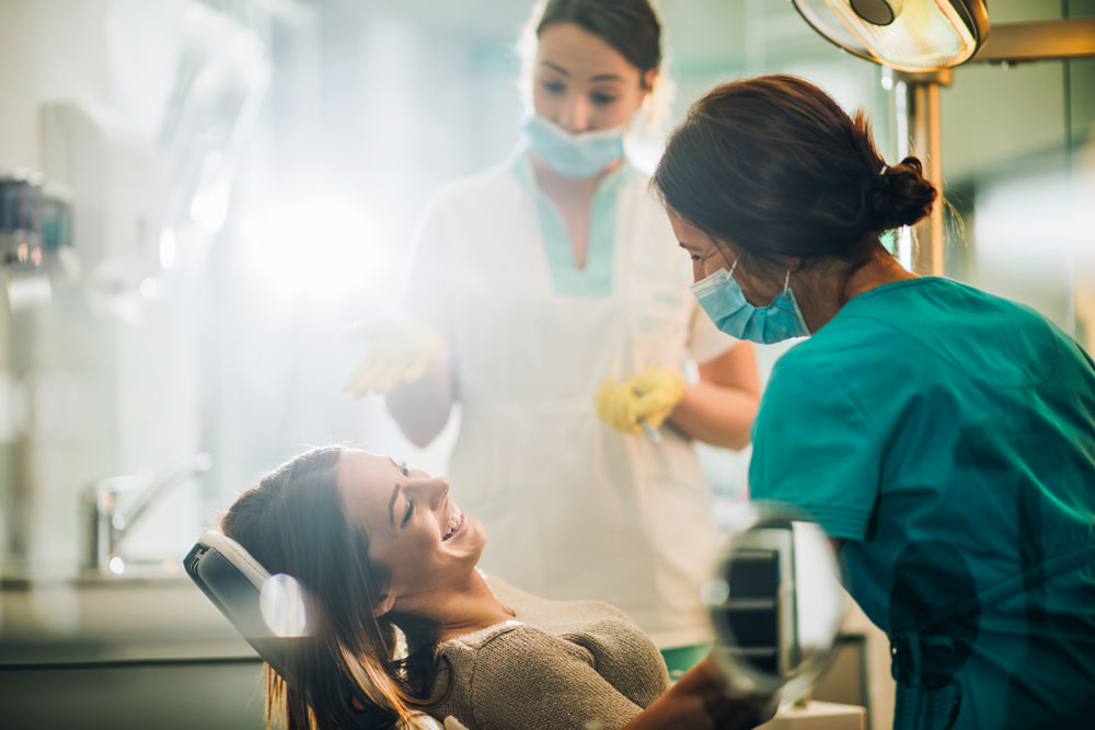 Two dental technicians with a female patient